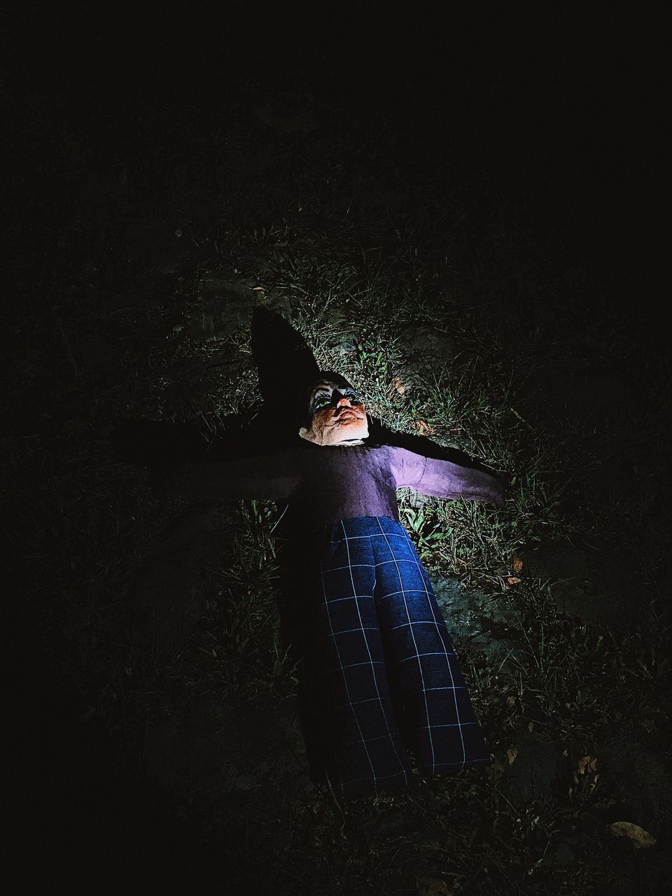 HIGH ANGLE VIEW OF WOMAN STANDING ON FIELD AT NIGHT