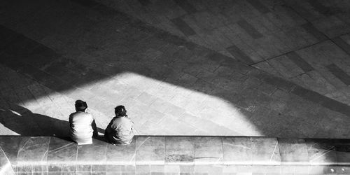 Rear view of people sitting on floor