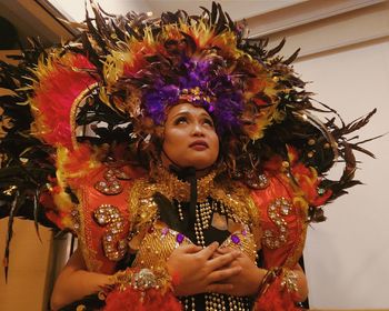 Depressed woman in traditional costume looking up while praying