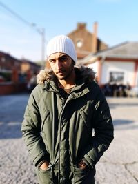 Portrait of man in warm clothes while standing in city 