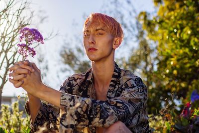 Portrait of man holding flowers