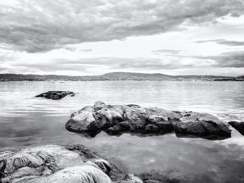 Scenic view of lake against cloudy sky