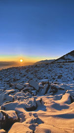 Scenic view of snowcapped mountains against clear sky during sunset