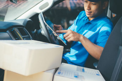 Man using digital tablet while sitting in car