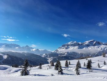 Scenic view of snowcapped mountains against blue sky