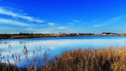 Scenic view of calm lake against blue sky