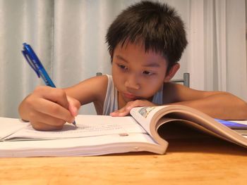 Close-up of boy studying at table