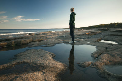 Woman standing on coast and looking at sea