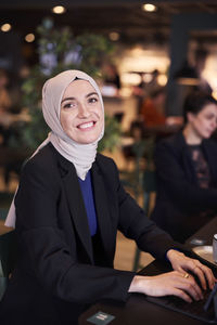 Businesswoman looking at camera in cafe