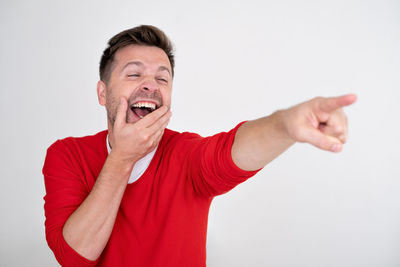 Portrait of young man gesturing against white background
