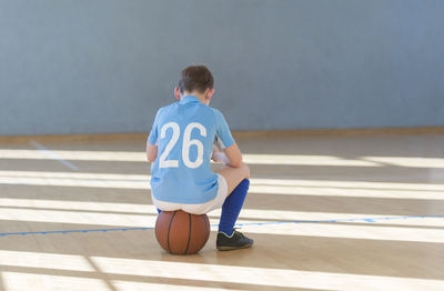 Rear view of boy playing with ball