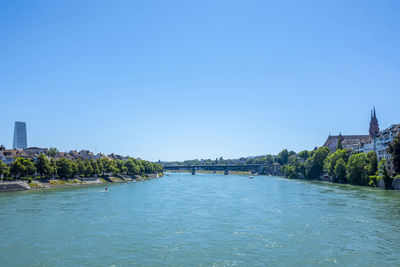 River passing through city against clear blue sky