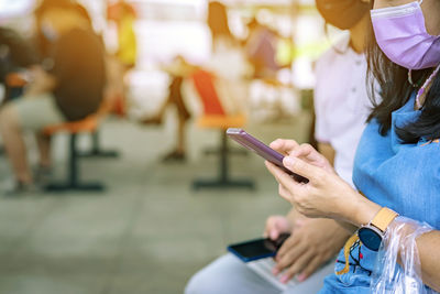 Midsection of woman holding mobile phone
