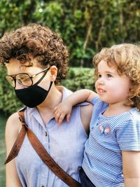 Brazilian mother wearing mask taking care of daughter in quarantine.