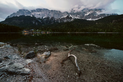 Scenic view of lake by mountains against sky