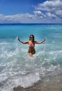 Portrait of young woman standing in sea