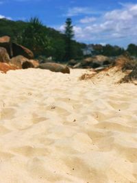 Close-up of sand at beach against sky