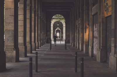 Rear view of man walking in corridor