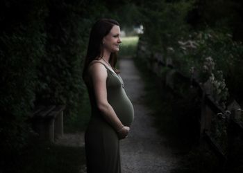 Side view of a young woman standing outdoors