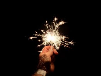 Close-up of hand holding sparkler at night