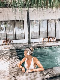 Full length of woman relaxing on swimming pool