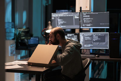 Man using laptop while sitting on table