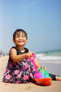 Cute girl at beach against sky