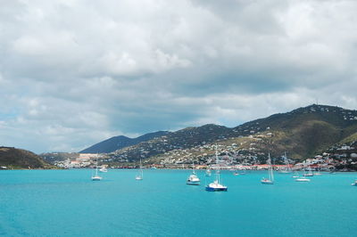 Sailboats in sea against sky