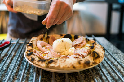 Cropped hand of person preparing food on table