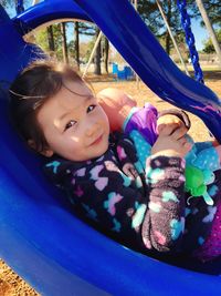 Close-up portrait of smiling girl playing at playground