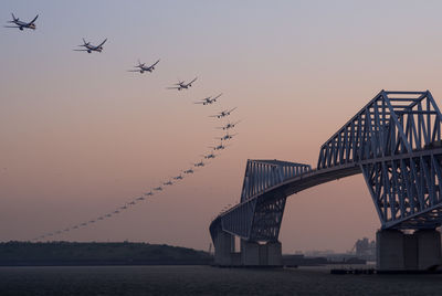 Bridge over river against sky during sunset