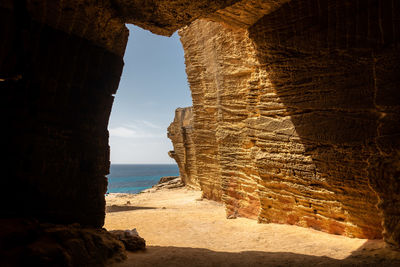 Rock formation on beach against sky