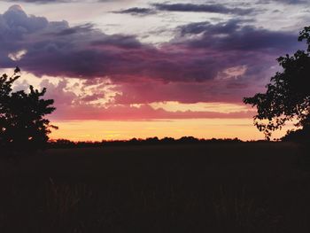 Scenic view of silhouette field against sky during sunset