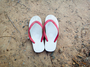 High angle view of flip-flops on sand