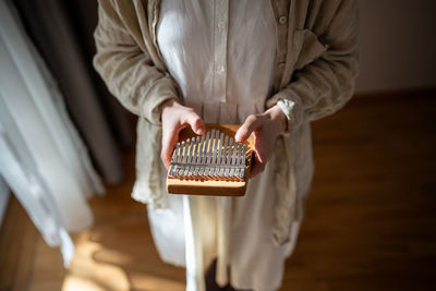 Midsection of man holding book on table