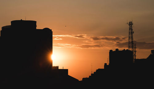 Silhouette buildings against sky during sunset