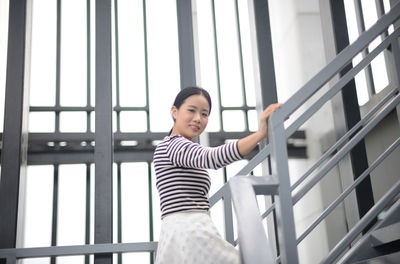 Low angle view of young woman standing on steps