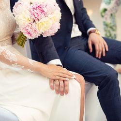 Midsection of couple holding flower bouquet