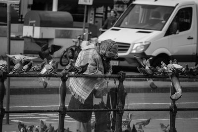 Old woman feeding pigeons