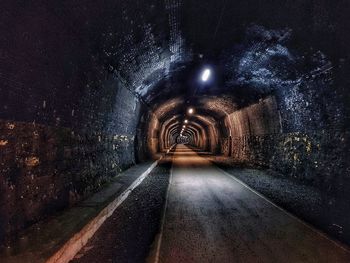 Empty road in illuminated tunnel