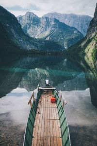 Boat moored in lake against mountains reflection at bavarian alps