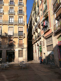 People walking on street amidst buildings in city