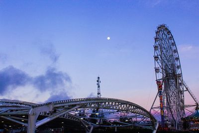 Low angle view of ferris wheel against blue sky