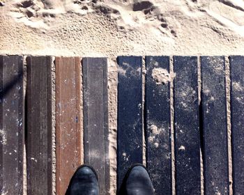 Low section of person standing on wooden surface