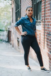 Young woman standing against building