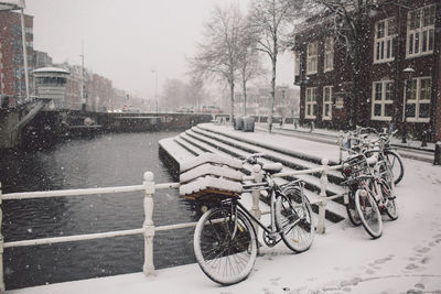 Bicycle on snow covered bridge over lake