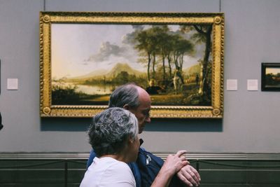 Rear view of couple kissing against window