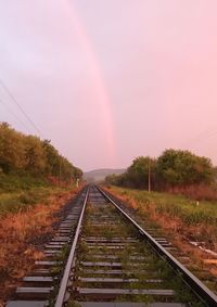 View of rainbow over railroad tracks against sky