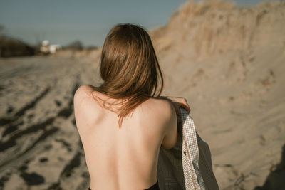 Rear view of woman standing at beach