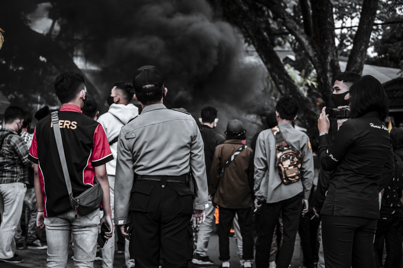 REAR VIEW OF PEOPLE WALKING ON STREET